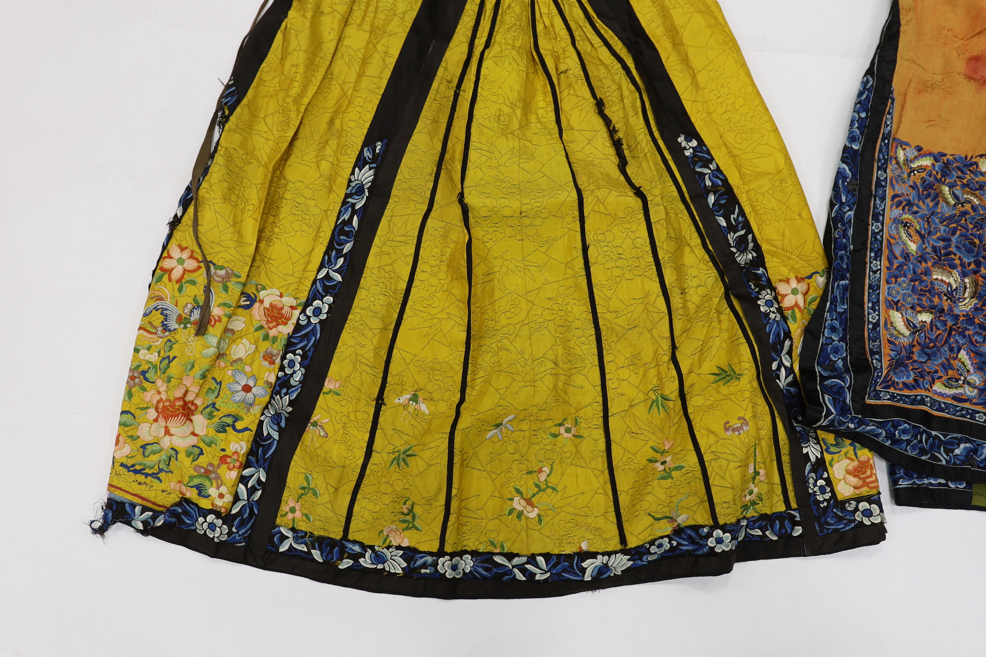A late Chinese Qing yellow silk damask wedding skirt, with polychrome coloured silk embroidery, together with a similar coral silk damask blue embroidered wedding skirt